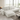 Canapé d’angle modulable en tissu bouclette blanc, style contemporain, dans un salon lumineux avec baie vitrée et décoration minimaliste