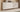 Buffet blanc moderne avec portes et tiroirs texturés, modèle épuré au style minimaliste, posé dans un salon lumineux au mur bois clair