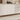 Buffet blanc moderne avec portes et tiroirs texturés, modèle épuré au style minimaliste, posé dans un salon lumineux au mur bois clair