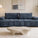 Canapé d’angle modulable en tissu bouclette blanc, style contemporain, dans un salon lumineux avec baie vitrée et décoration minimaliste