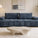 Canapé d’angle modulable en tissu bouclette blanc, style contemporain, dans un salon lumineux avec baie vitrée et décoration minimaliste